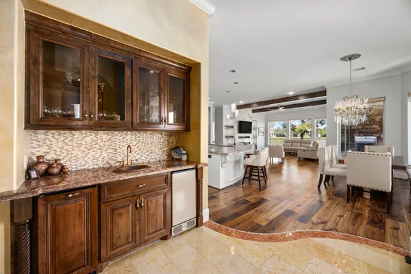 a kitchen with stainless steel appliances kitchen island granite countertop a table chairs in it and white cabinets