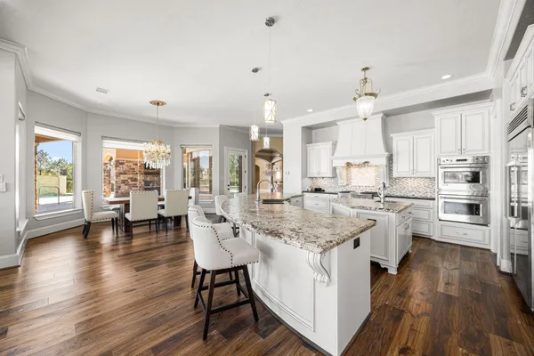 a living room with furniture a flat screen tv and kitchen view