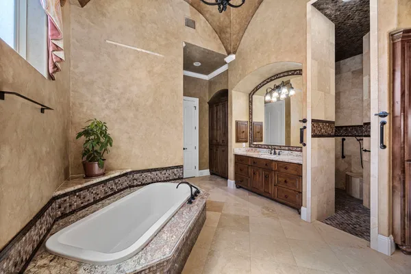 a bedroom with a bed and a flat tv screen on dresser