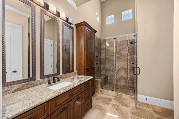 a bathroom with a granite countertop double vanity sink and a mirror