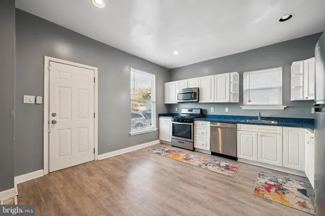 a kitchen with granite countertop white cabinets and appliances