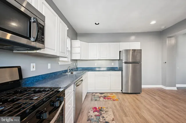 a kitchen with stainless steel appliances granite countertop a refrigerator and a stove top oven