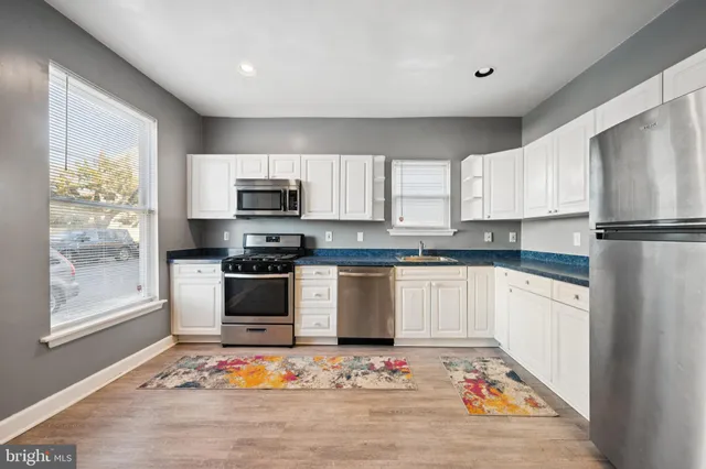 a kitchen with granite countertop a refrigerator stove and microwave