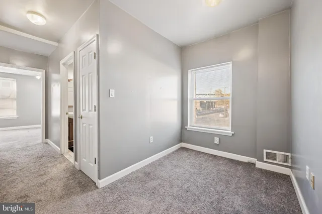 an empty room with windows and closet