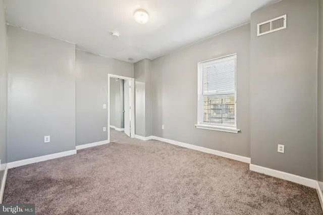 an empty room with windows and closet