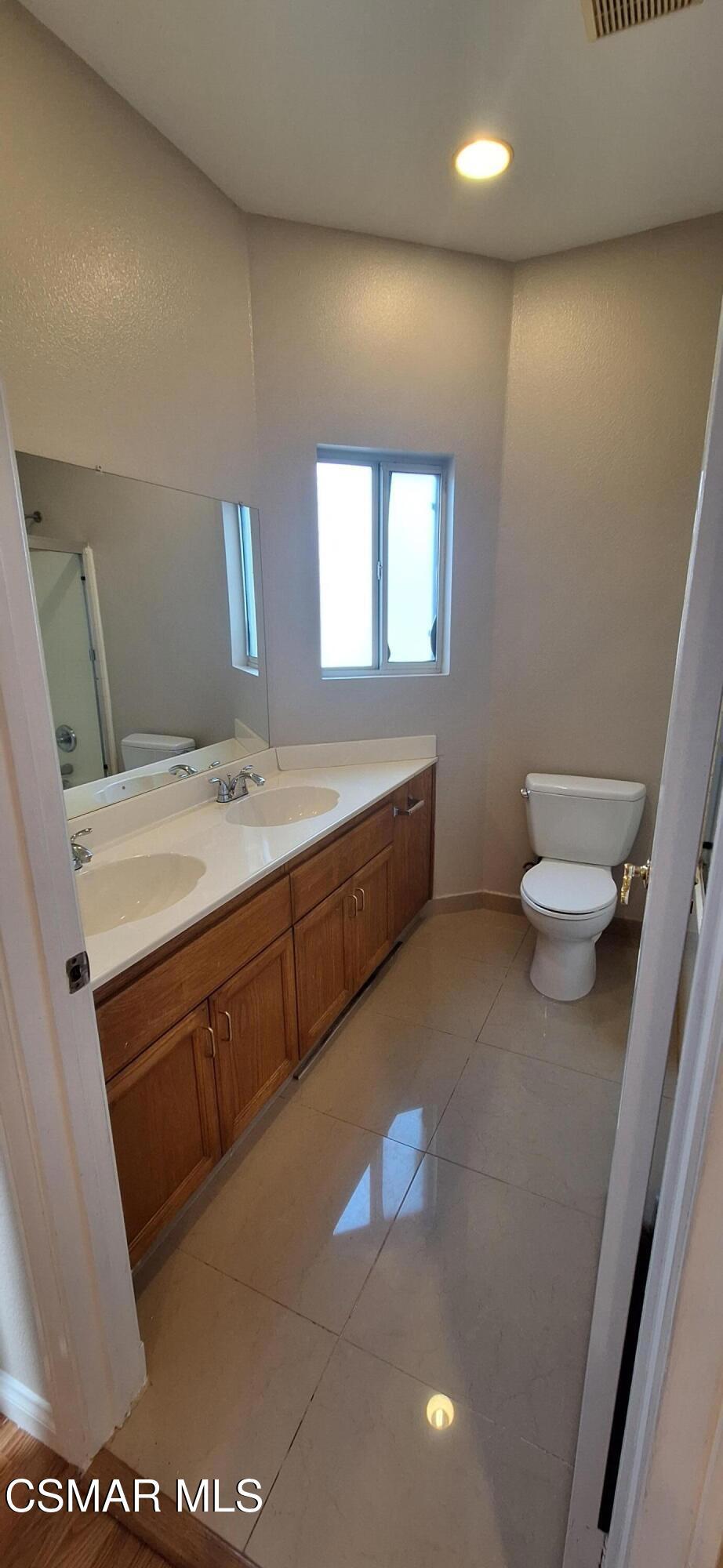 7337 Balboa Boulevard, Unit 5 Van Nuys, CA 91406 - Photo 12 of 13 a bathroom with a sink a toilet and a mirror