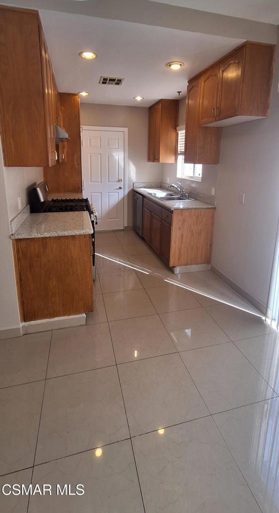 7337 Balboa Boulevard, Unit 5 Van Nuys, CA 91406 - Photo 5 of 13 a large kitchen with stainless steel appliances a stove a sink and a refrigerator