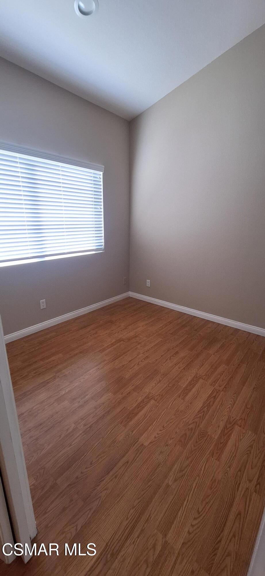 7337 Balboa Boulevard, Unit 5 Van Nuys, CA 91406 - Photo 9 of 13 an empty room with wooden floor and windows