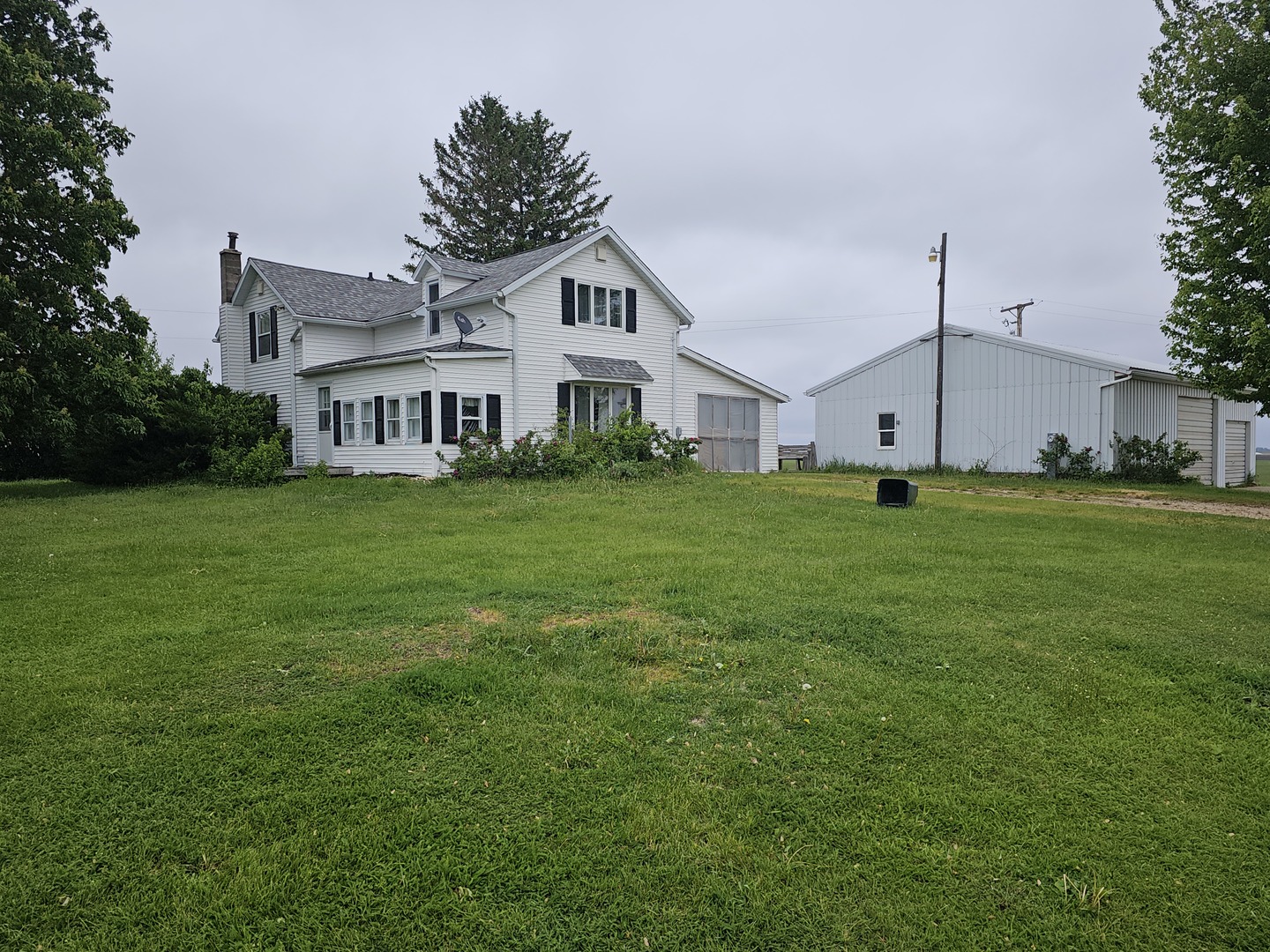 a big white house with a big yard and large trees
