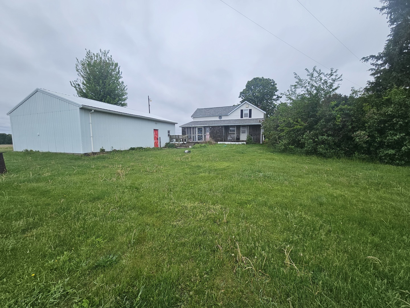 23018 Freeport Road Sterling, IL 61081 - Photo 19 of 19 a view of a house with a big yard potted plants and a large tree
