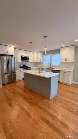 a large kitchen with kitchen island a sink stainless steel appliances and cabinets