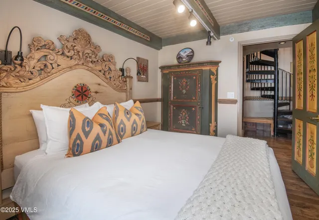 a bedroom with bed and wooden floor