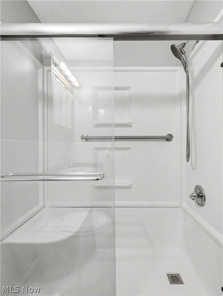 3064 Kent Road Stow, OH 44224 - Photo 17 of 30 Shower stall with sliding glass door, integrated seating, and handheld shower fixture