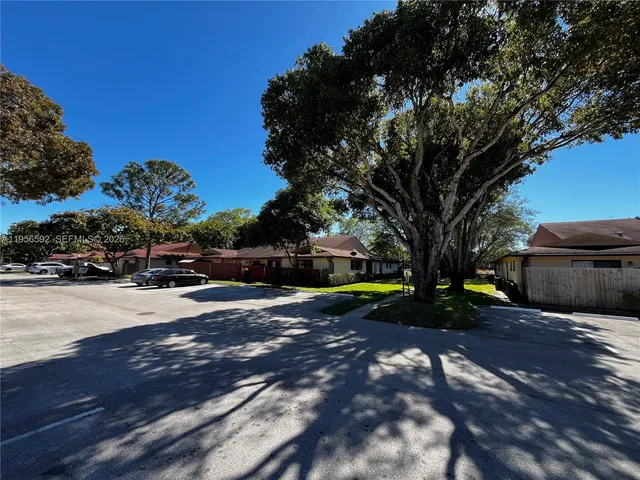 a view of a street with a building and trees in the background
