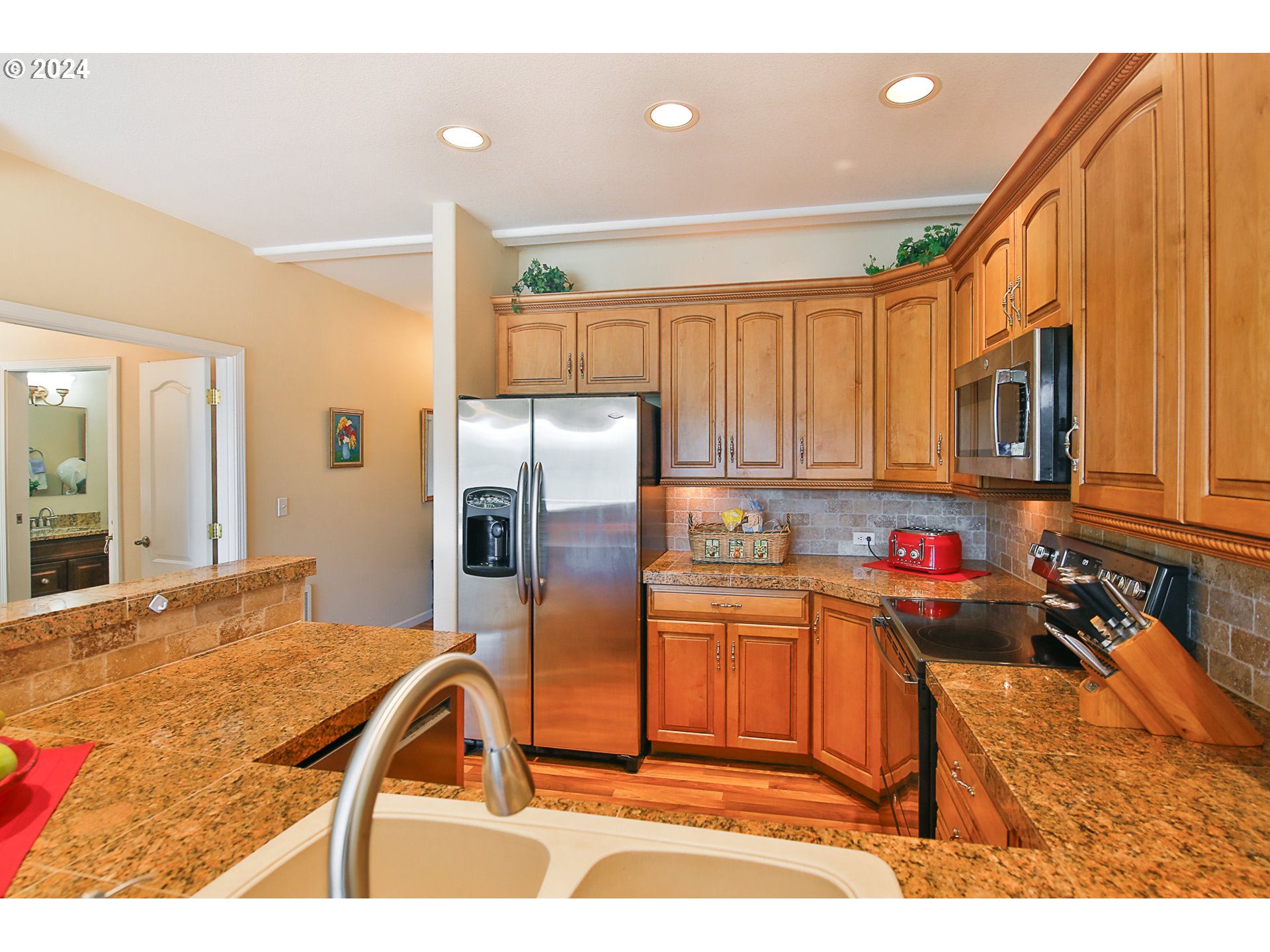 311 Council Hill Road Lakeside, OR 97449 - Photo 19 of 42 a kitchen with stainless steel appliances granite countertop a refrigerator and a sink