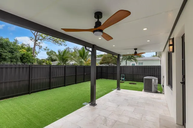 a view of a backyard with furniture and wooden fence