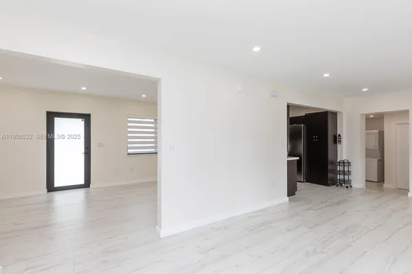 a view of an empty room with wooden floor and closet