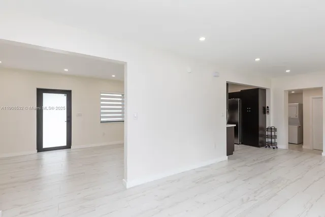 a view of an empty room with wooden floor and closet