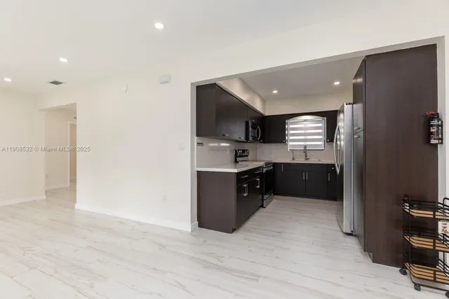 a large kitchen with a refrigerator and a sink