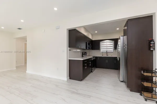 a large kitchen with a refrigerator and a sink
