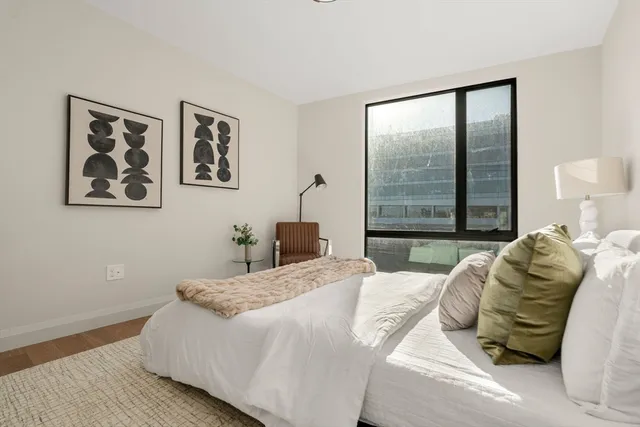 a bedroom with a bed and a large window