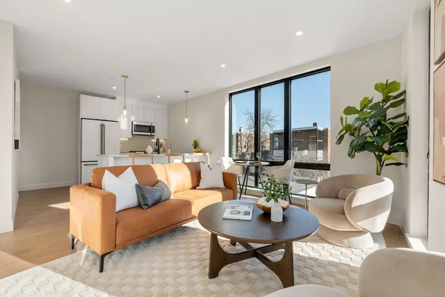 a living room with furniture kitchen view and a potted plant
