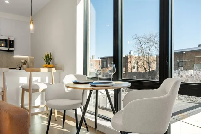a dining room with furniture a rug and a floor to ceiling window