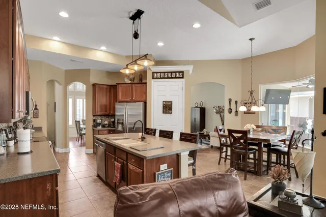 a bathroom with a sink double vanity a toilet a tub and a large mirror