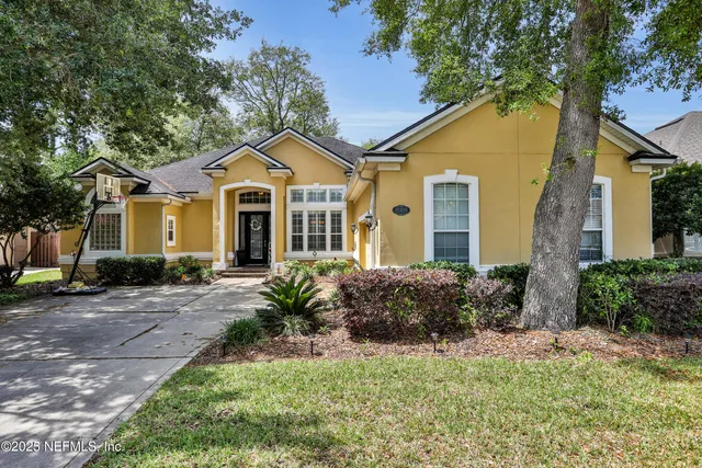 a front view of a house with a yard and potted plants