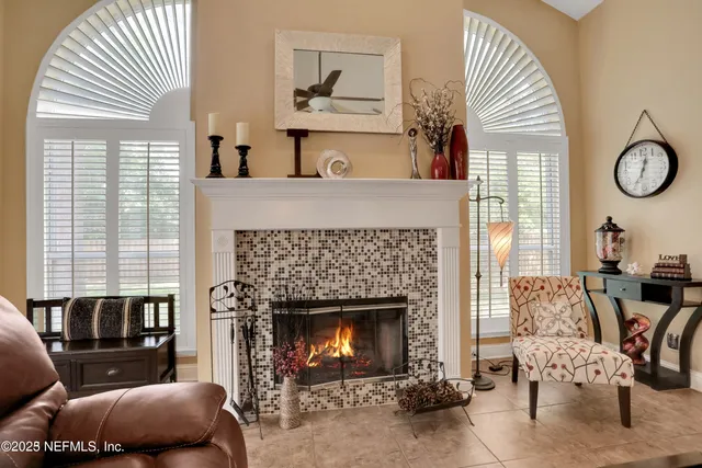 a living room with furniture potted plant and a large window