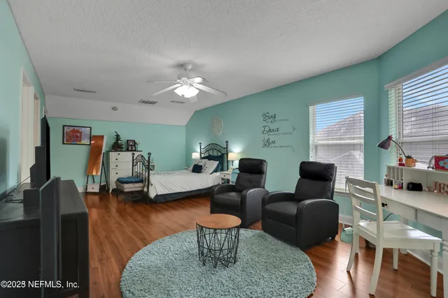 a view of a patio with table and chairs potted plants and floor to ceiling window