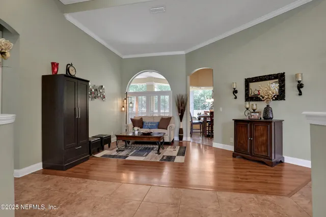 a living room with furniture a large window and wooden floor