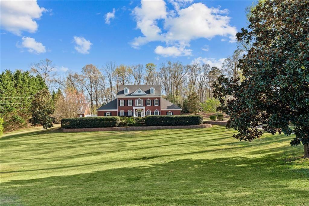 a view of a fountain in front of a house with a big yard