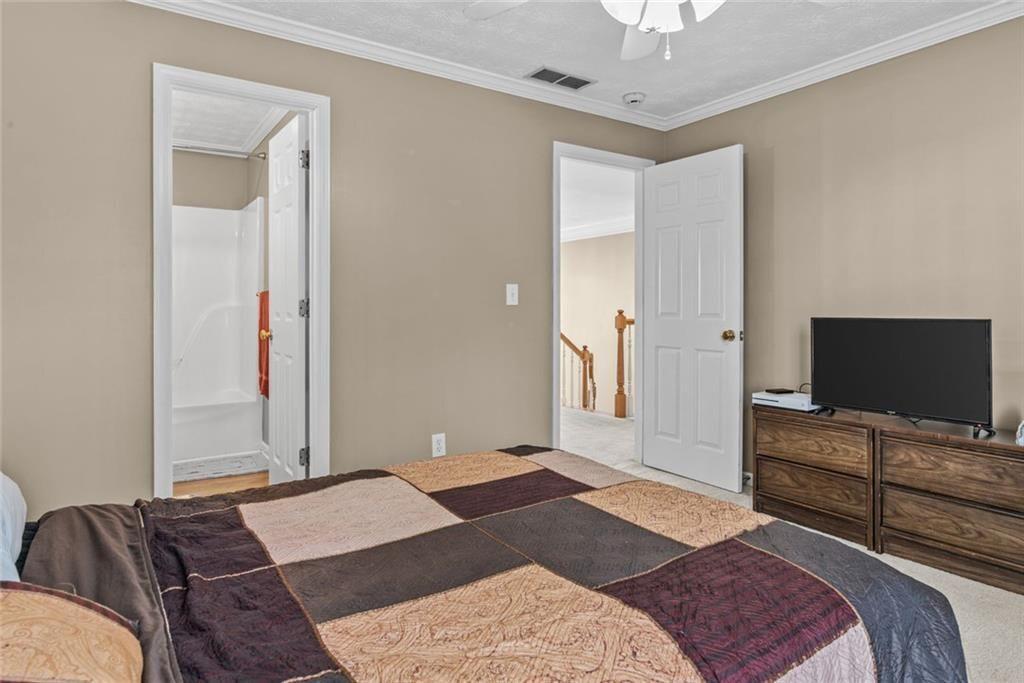 168 Jersey Road Oxford, GA 30054 - Photo 42 of 59 a bedroom with a bed and a flat tv screen on dresser
