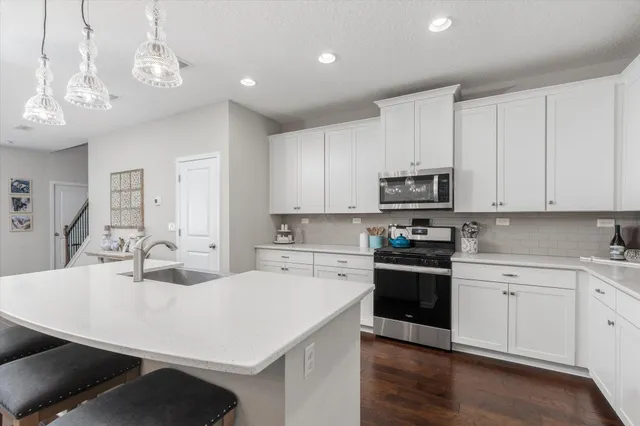 a kitchen with a sink a stove and cabinets