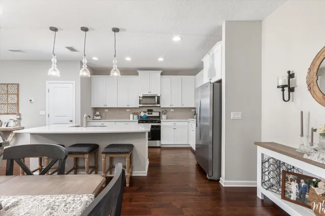 a kitchen with kitchen island a sink stainless steel appliances and cabinets