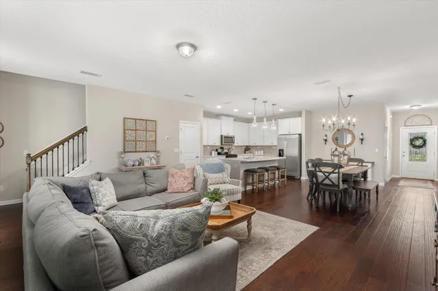a living room with furniture kitchen view and a dining table