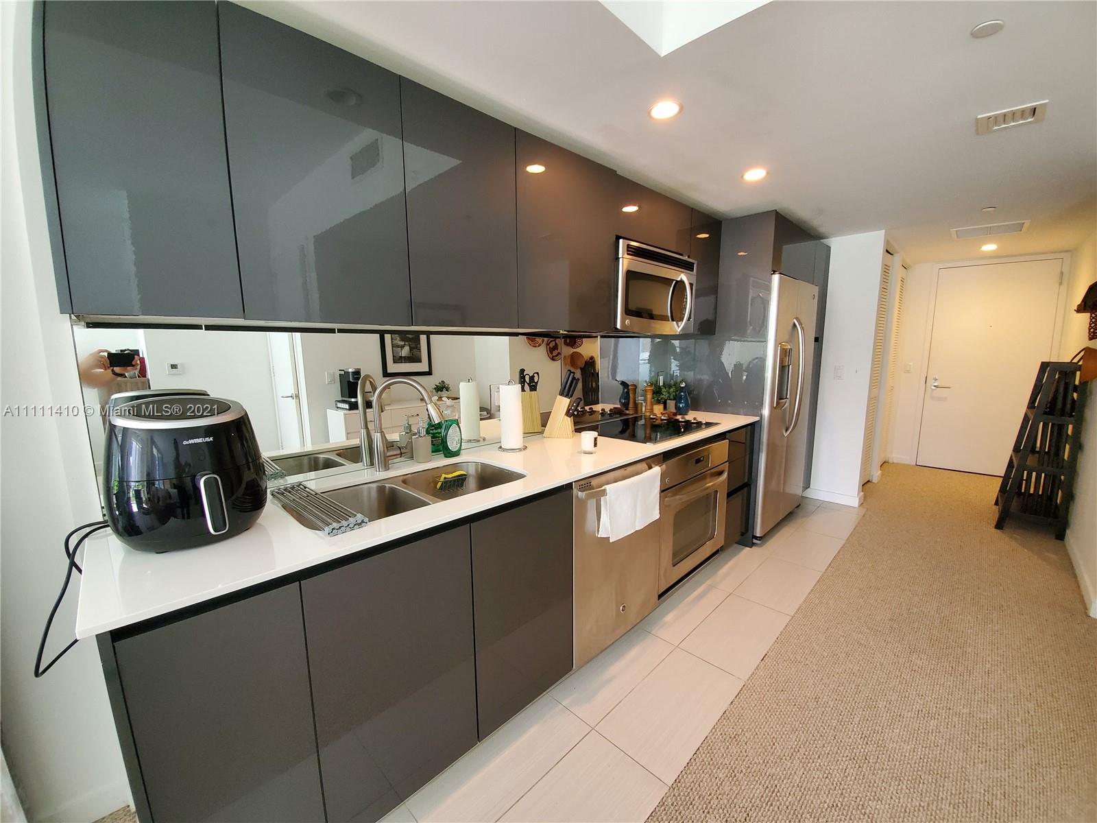 31 Southeast 6th Street, Unit 505 Miami, FL 33131 - Photo 13 of 71 a kitchen with a sink and cabinets