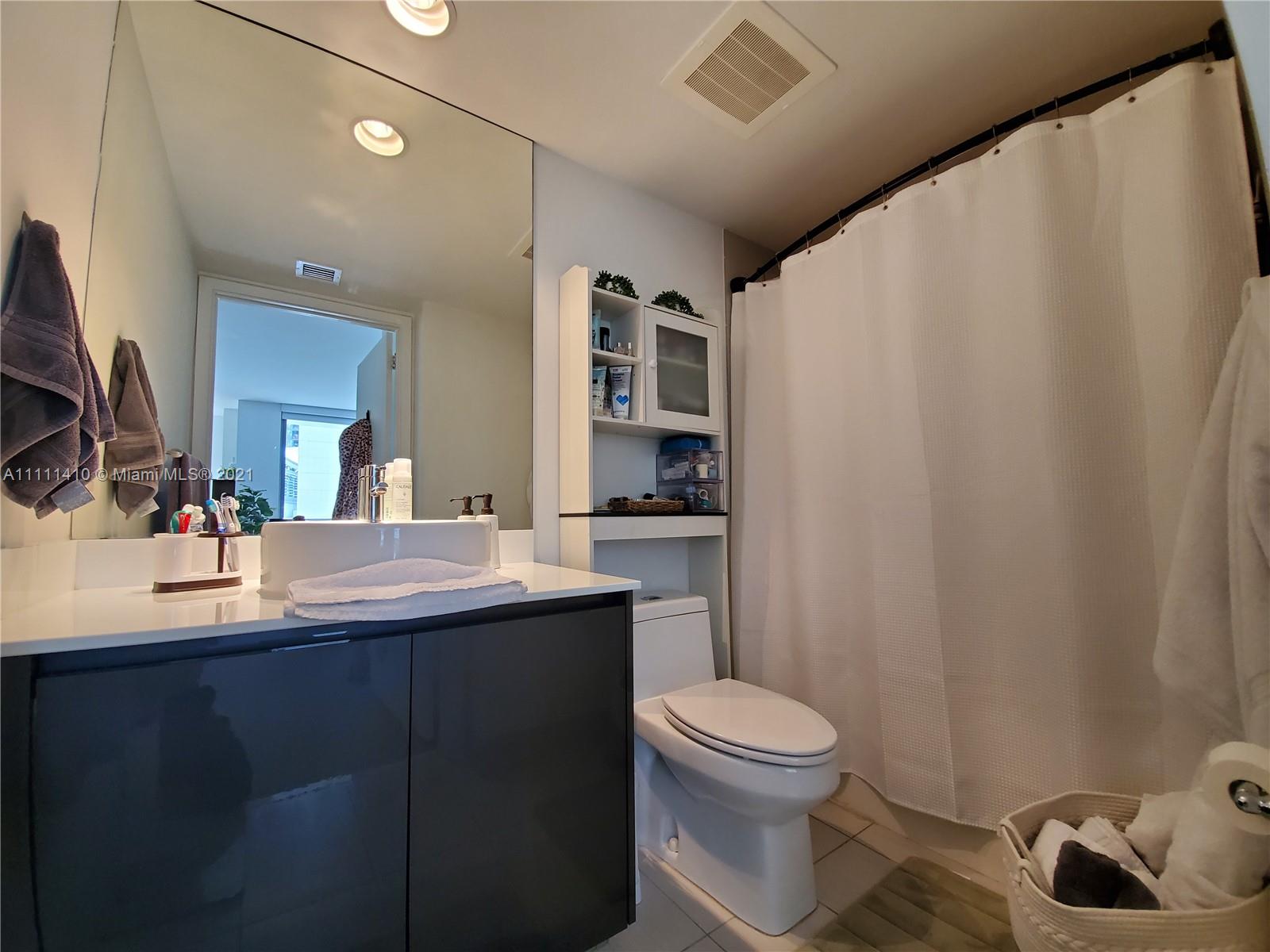 31 Southeast 6th Street, Unit 505 Miami, FL 33131 - Photo 16 of 71 a bathroom with a sink toilet a mirror and vanity