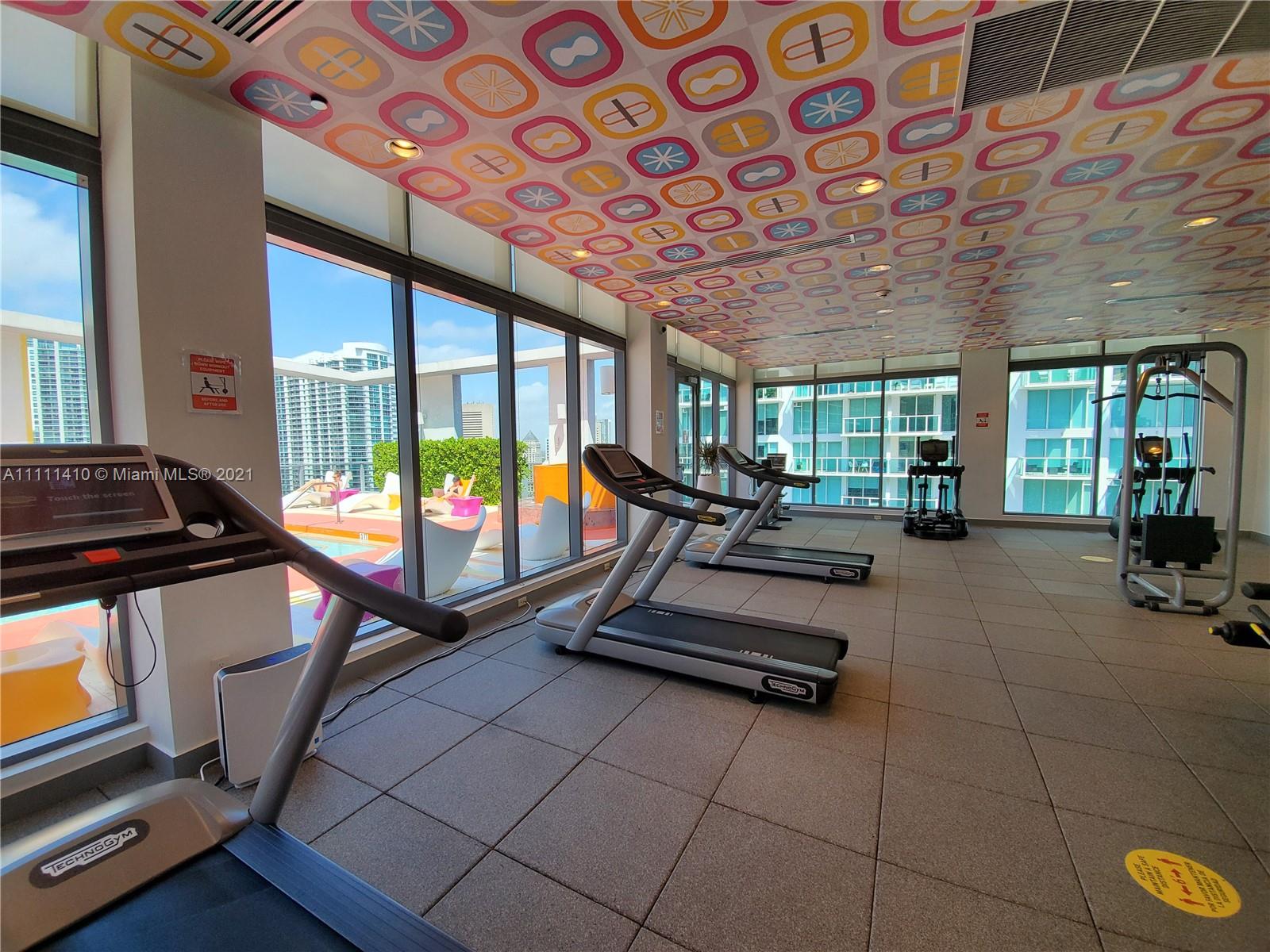 31 Southeast 6th Street, Unit 505 Miami, FL 33131 - Photo 33 of 71 a room with gym equipment and a large window