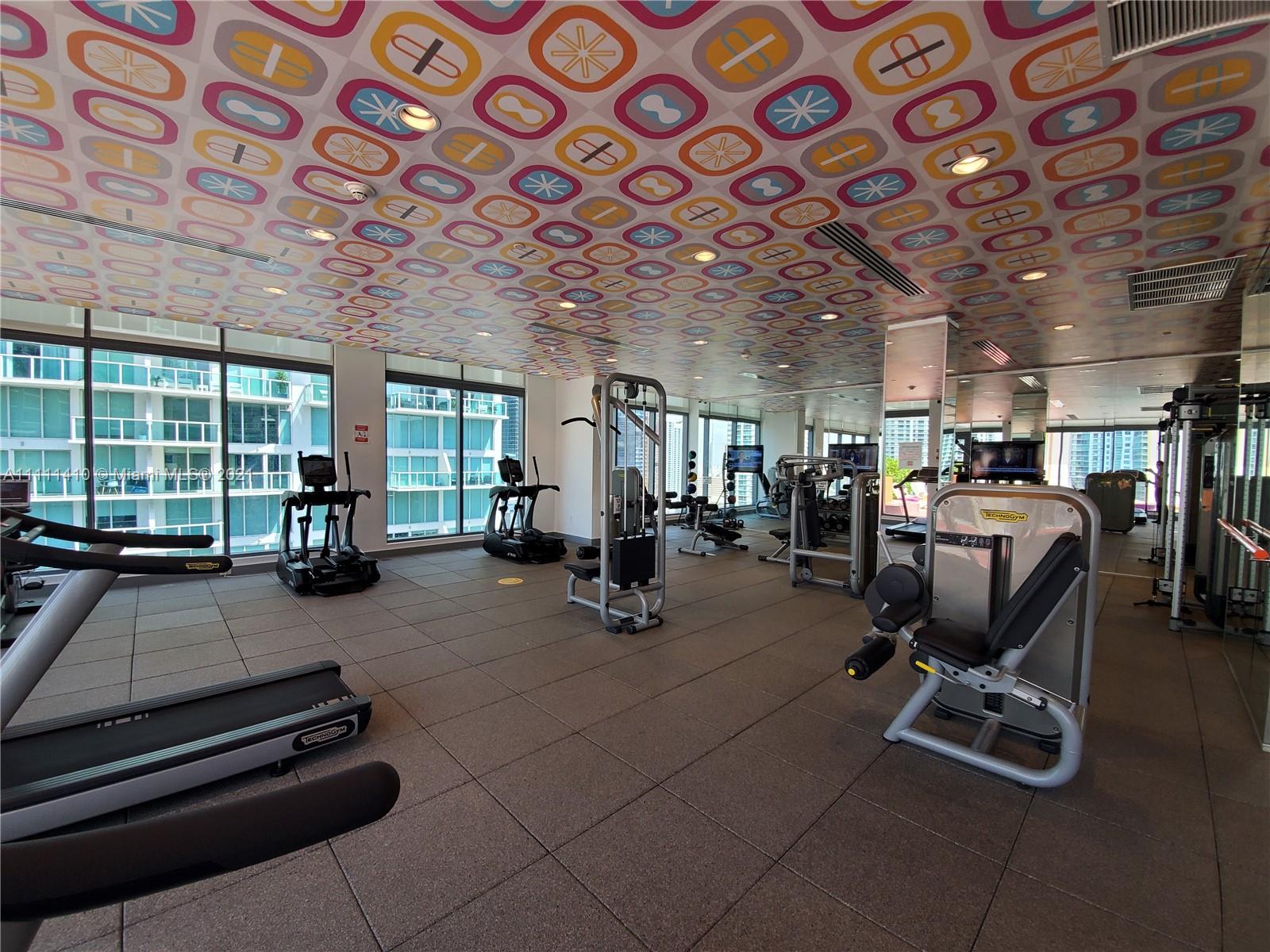 31 Southeast 6th Street, Unit 505 Miami, FL 33131 - Photo 34 of 71 a room with gym equipment and a chandelier