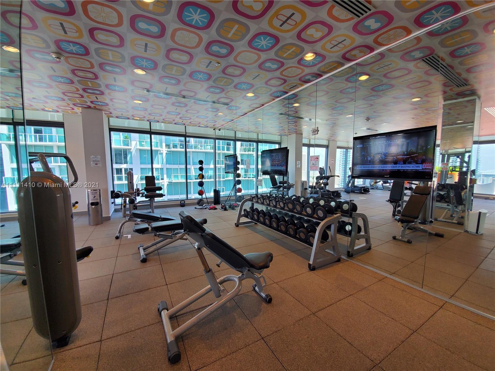31 Southeast 6th Street, Unit 505 Miami, FL 33131 - Photo 35 of 71 a living room with lots of furniture and a flat screen tv