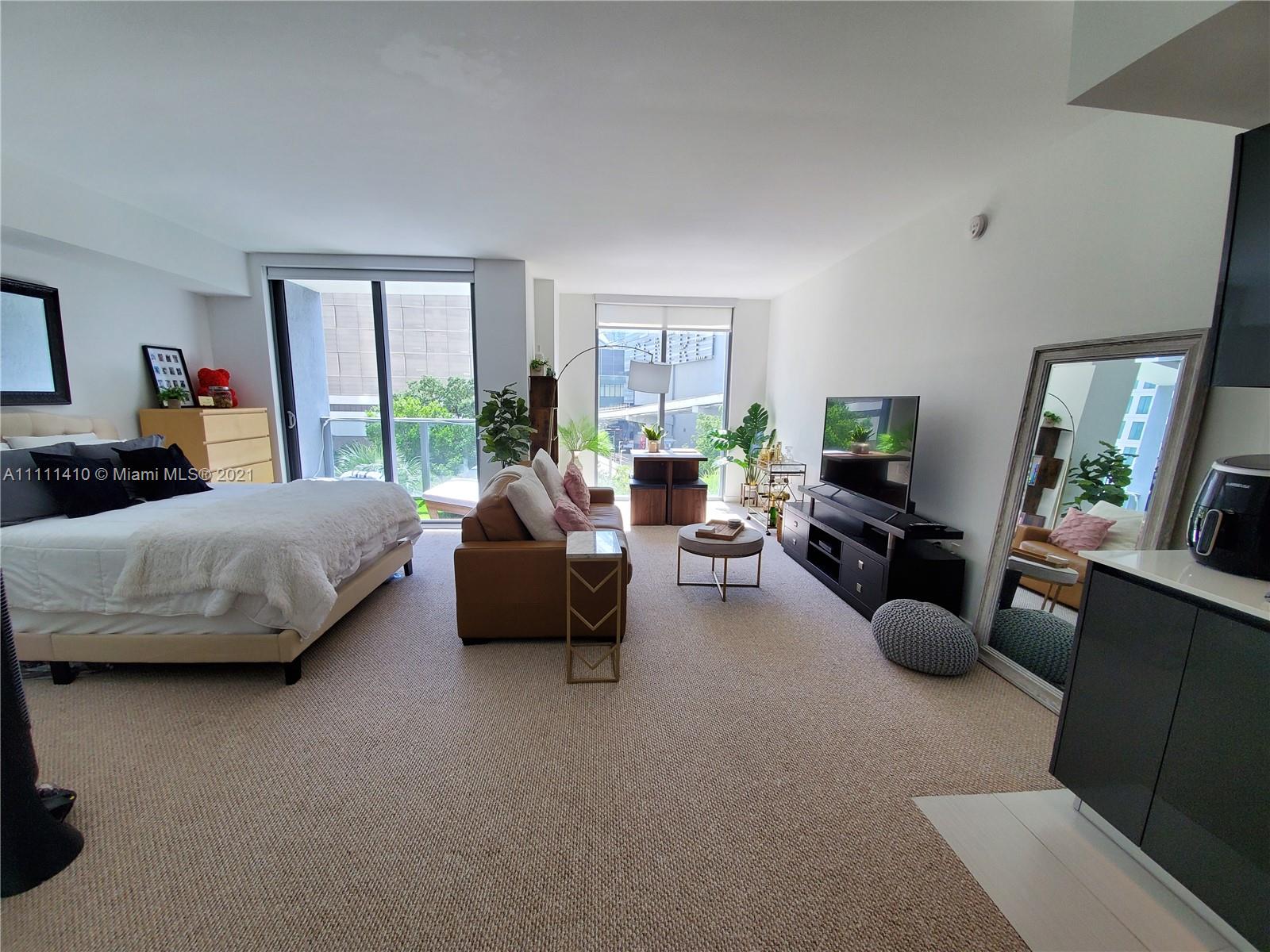 31 Southeast 6th Street, Unit 505 Miami, FL 33131 - Photo 6 of 71 a living room with furniture and a flat screen tv