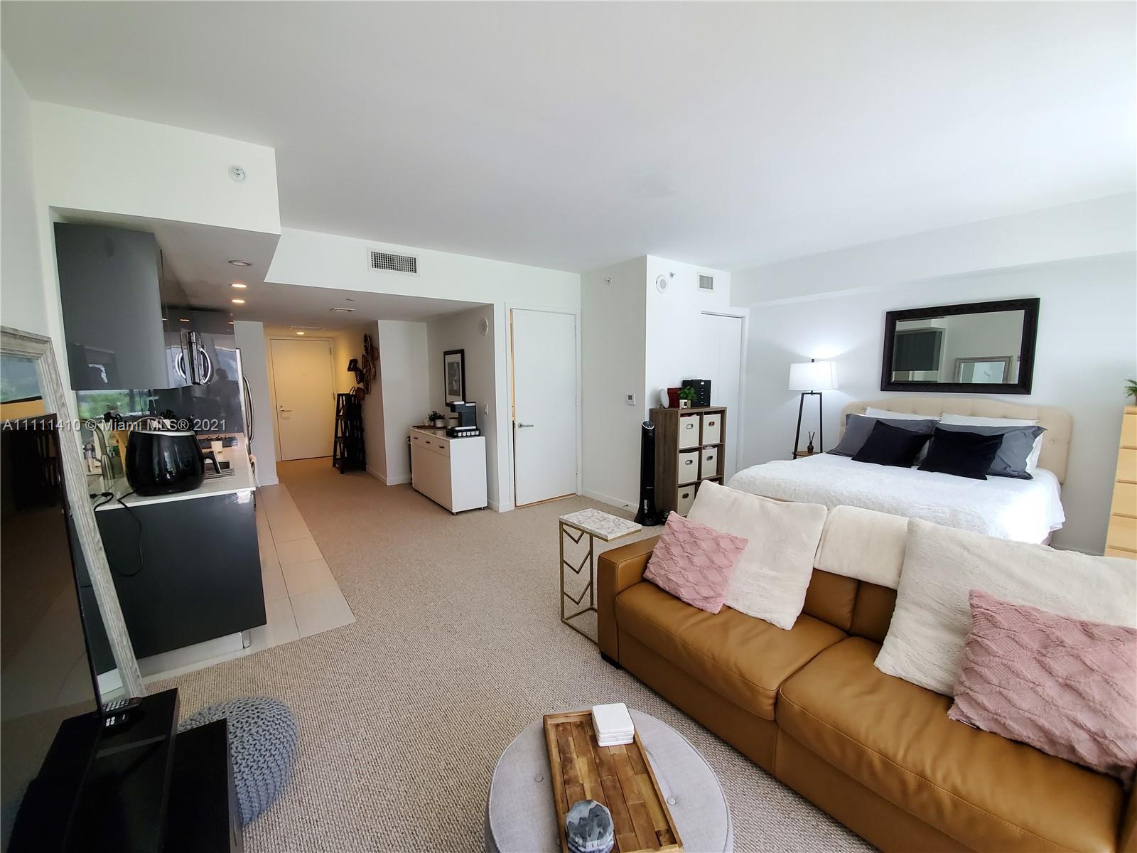 31 Southeast 6th Street, Unit 505 Miami, FL 33131 - Photo 9 of 71 a bedroom with furniture and a flat screen tv