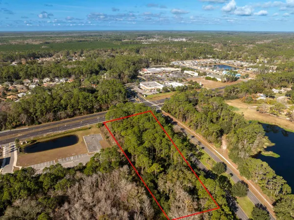 an aerial view of residential houses with outdoor space and trees