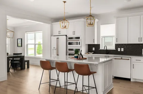 a kitchen with stainless steel appliances kitchen island granite countertop a stove a sink a dining table and chairs