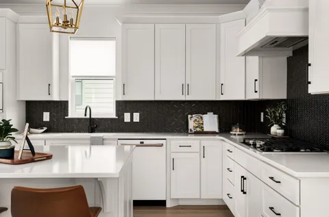 a kitchen with granite countertop white cabinets and black appliances