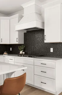 a kitchen with granite countertop white cabinets and white appliances