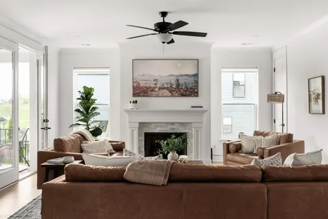 a living room with furniture a chandelier and a fireplace