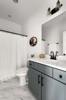 a bathroom with a sink a toilet and a mirror